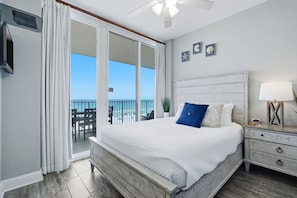 A bedroom with a bed, a nightstand, a lamp, a ceiling fan, and a view of the ocean through a sliding door. - NEW LISTING!!! Lighthouse #418 Gulf Front w/HUGE Corner Balcony! (Gulf Shores)