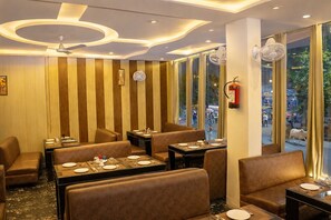 Een restaurant met zitbanken en tafels, een plafondventilator en een brandblusser.