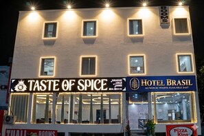 Een gebouw met borden voor 'TASTE OF SPICE' en 'HOTEL BRASIL', wat een restaurant en hotel aangeeft.