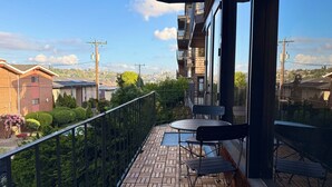 Un balcón con vistas a un paisaje urbano, una mesa y sillas.