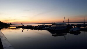 Ein Yachthafen mit vertäuten Booten im ruhigen Wasser bei Sonnenuntergang.