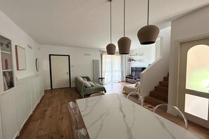 Ein modernes Interieur mit Essbereich, einer Sitzecke und einer Treppe.