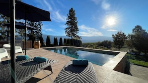 A swimming pool with a view of mountains, outdoor furniture, and a pergola. - Summerland Lakeview Vineyard with Pool (Summerland)