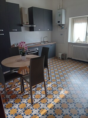 A kitchen with a dining table, chairs, and a potted plant. - BGM Apartment Milan Rho Fiera—trains every 15 minutes to Milan (Cesate)