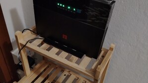A television on a wooden stand with a power cord plugged in. - BGM Apartment Milan Rho Fiera—trains every 15 minutes to Milan (Cesate)
