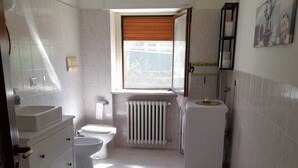 A bathroom with a toilet, sink, and radiator. - BGM Apartment Milan Rho Fiera—trains every 15 minutes to Milan (Cesate)