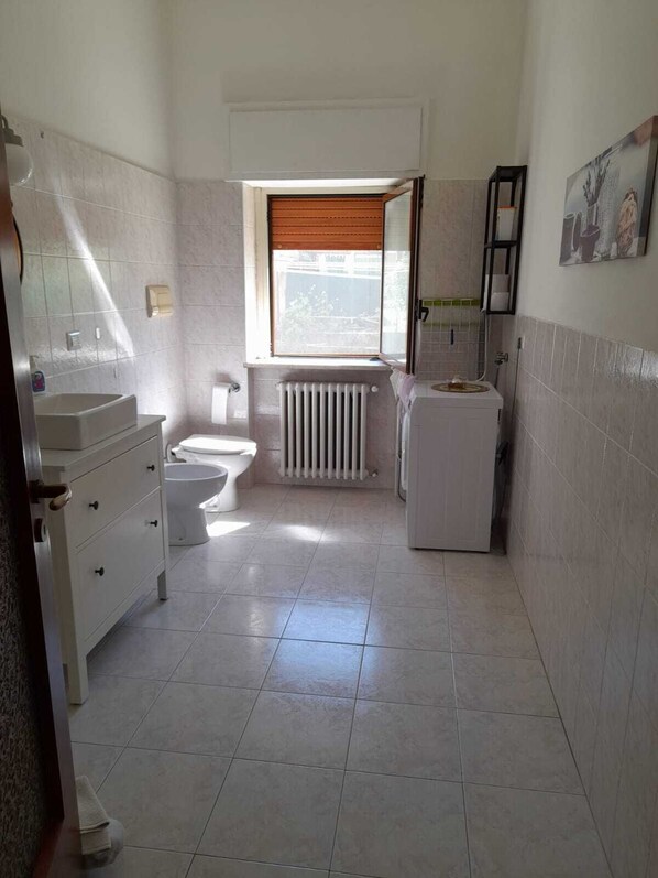 Ein Badezimmer mit Toilette, Waschbecken und Heizkörper.