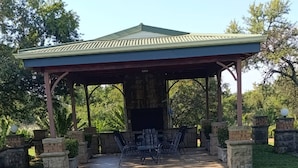 A covered patio area with a pool, stone planters, and outdoor furniture.