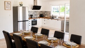 Une cuisine moderne avec un coin repas aménagé pour six personnes.