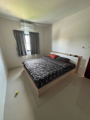 Un dormitorio con cama, cortinas, ventana y una lámpara en el techo.