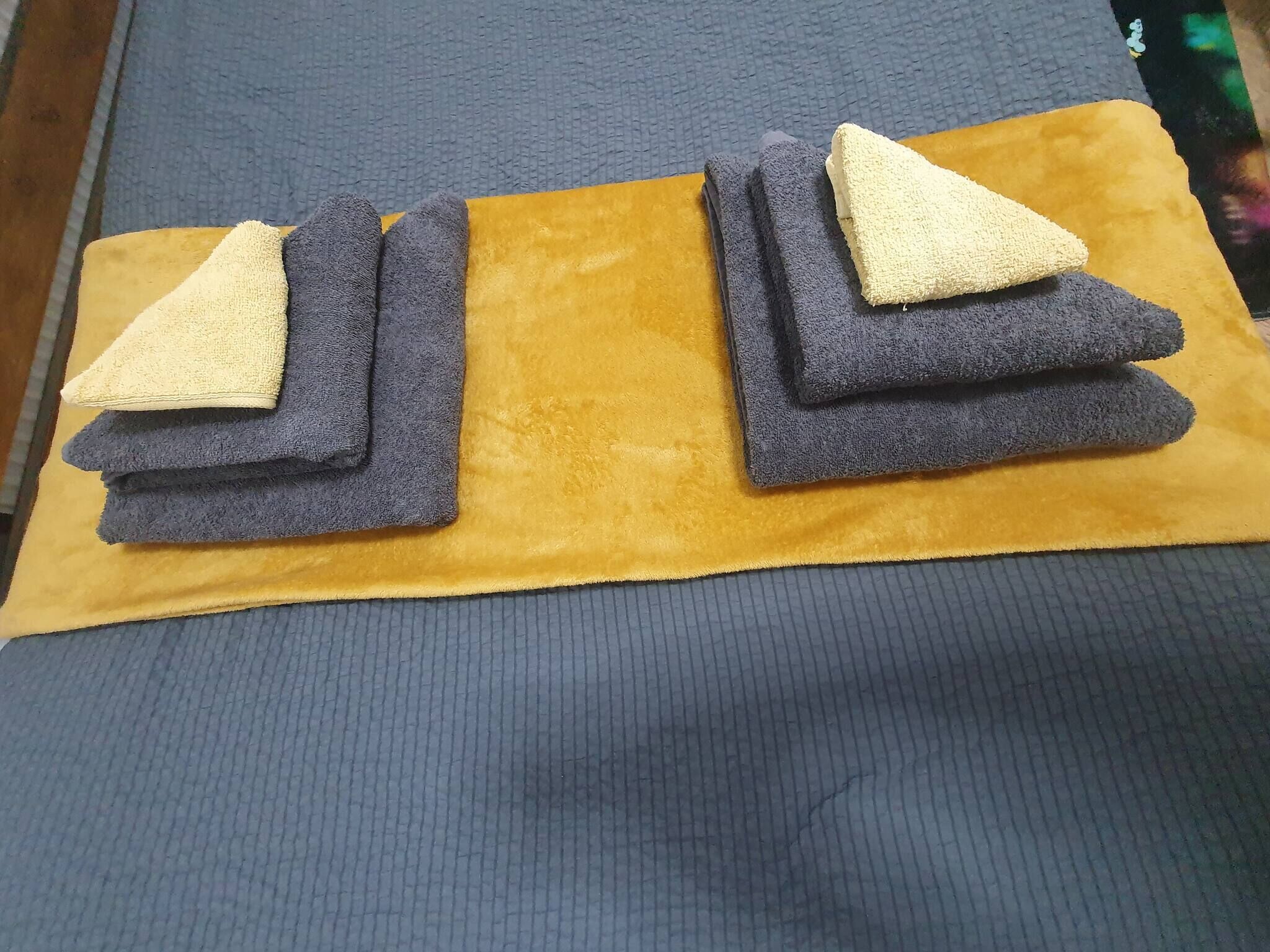A bed with a blue mattress and a yellow blanket.