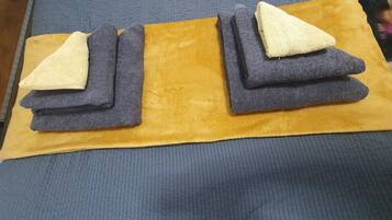 A bed with a blue mattress and a yellow blanket.