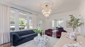 Ett vardagsrum med en svart soffa, ett runt soffbord i marmor och en beige soffa.