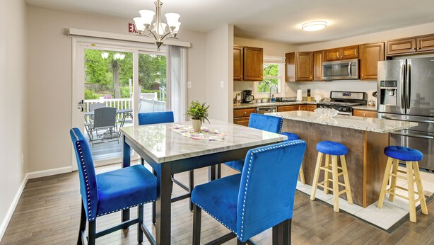 A modern kitchen with a central island, wooden cabinets, and stainless steel appliances. - Fenced Yard! Family Home, 14 Mi to DC Sites (Lanham)
