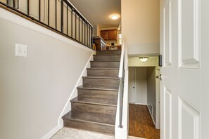A staircase leading to a kitchen area with wooden steps and a white door at the bottom. - Fenced Yard! Family Home, 14 Mi to DC Sites (Lanham)