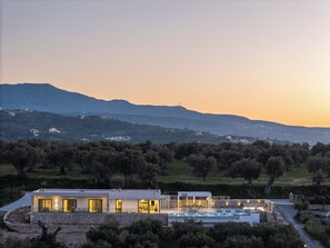 A modern house with a swimming pool, surrounded by trees and hills. - Simplicity of Single-Level Sea Views by etouri (Rethymno)