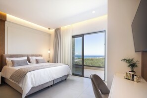 A modern bedroom with a large bed, a desk, and a view of the outdoors. - Simplicity of Single-Level Sea Views by etouri (Rethymno)