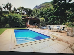 Una piscina amb gandules i un edifici petit al fons.