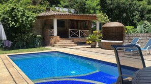 A swimming pool with a tiled edge, a small brick structure with a chimney, and a covered seating area with lounge chairs. - Lagoon Hostel - Pousada  (Rio de Janeiro)