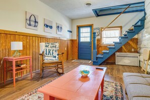 A room with a wooden floor, a blue door, a staircase, a rocking chair, a table, and a couch. - Monticello’s river country Family Retreat. (Monticello)