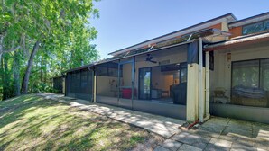 Una casa moderna con amplios ventanales, un espacio exterior cubierto y un césped bien cuidado.