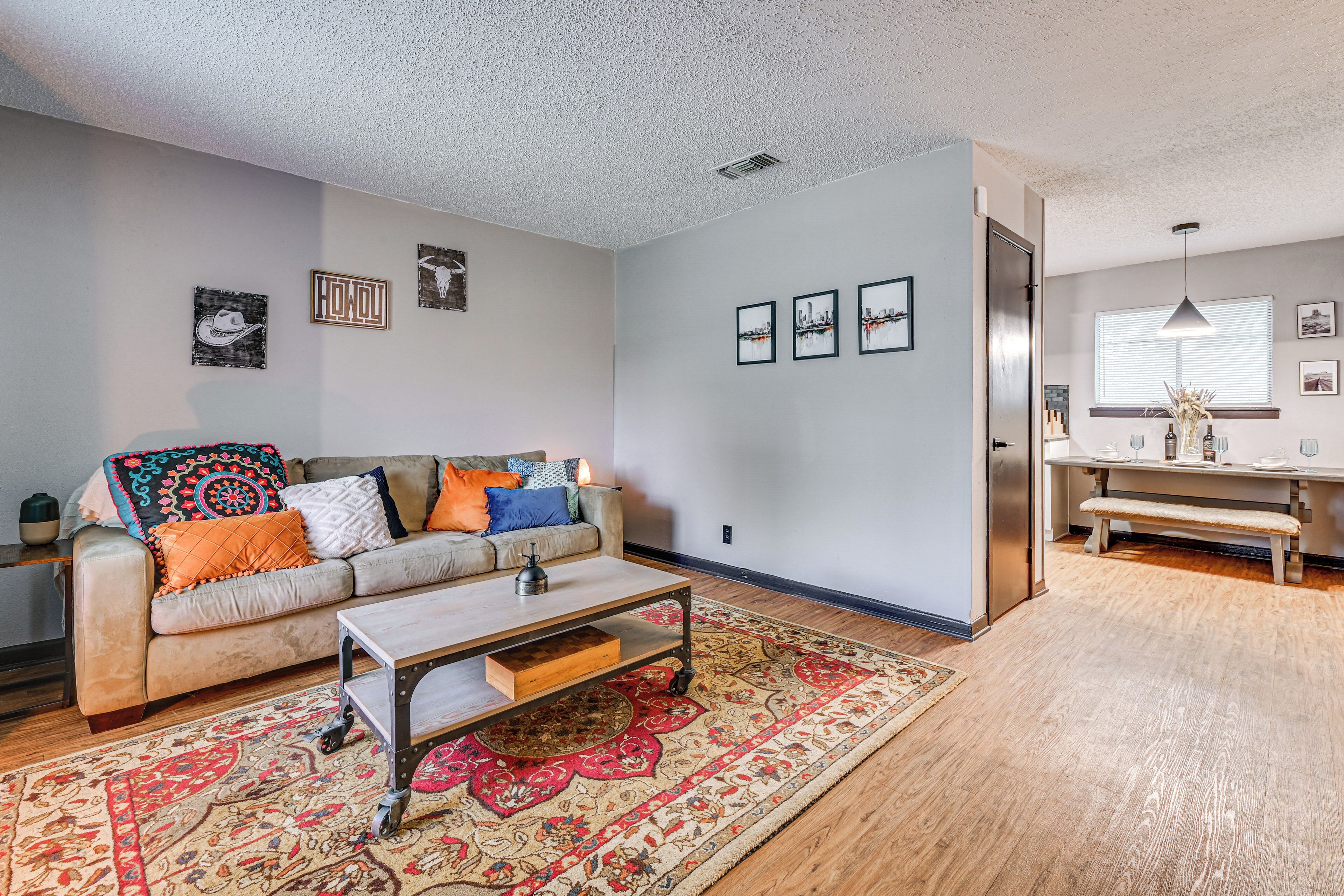 A living room with a sofa, coffee table, and patterned rug.