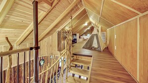A wooden interior with a staircase, a rope ladder, and a tent-like structure. - Beach Access Historic Cabin on Henderson Bay! (Gig Harbor)