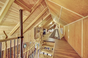 Ein Holzeinrichtung mit Treppe, Holzwänden und einer zeltartigen Konstruktion.