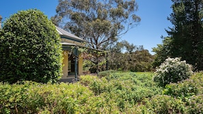 A house surrounded by lush greenery and flowering plants. - Woodman Estate by Property Mums (Moorooduc)