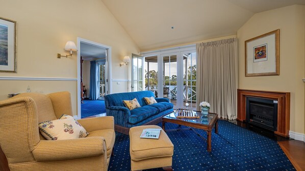 A living room with a blue sofa, a yellow armchair, a coffee table, and a fireplace.