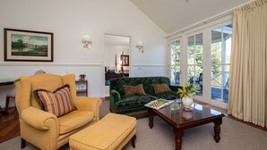 A living room with a yellow armchair, green sofa, and a wooden coffee table.