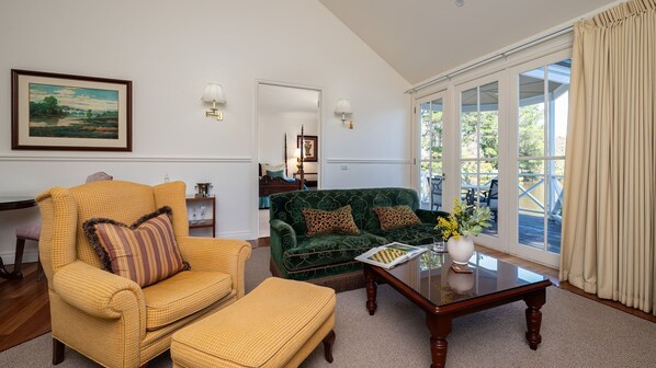Una sala de estar con un sillón amarillo, un sofá verde y una mesa de centro de madera.