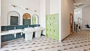 Ein modernes Badezimmer mit drei Waschbecken, einem Spiegel und einem Ablagebereich.