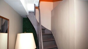 A staircase with a handrail, a wall with a light switch, and a lamp. - Holiday stay in center of Verviers (Verviers)