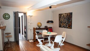 A modern living room with a wooden floor, a round table with chairs, a globe, a painting, and a clock. - Holiday stay in center of Verviers (Verviers)