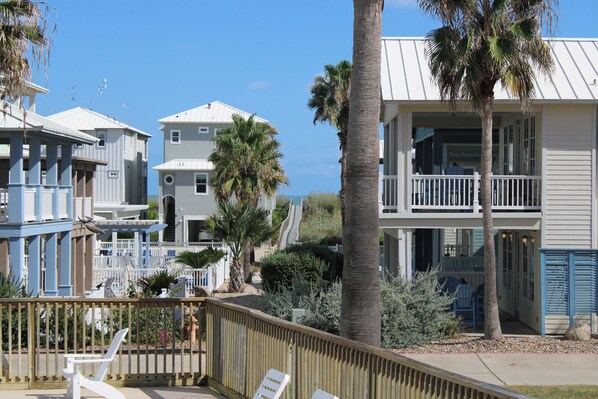 A beachfront property with multiple-story buildings, a wooden deck, and a clear view of the ocean. - Boardwalk to Port Aransas Beach! Condo w/ Pool (Port Aransas)