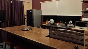 Una cucina con isola centrale, un lampadario e un forno a microonde.