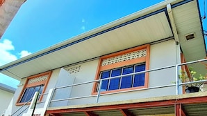 Un edificio a due piani con un balcone, ampie finestre e una porta ben visibile.