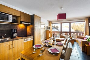 Eine moderne Küche mit Holzschränken, einer Mikrowelle und einer Kaffeemaschine.