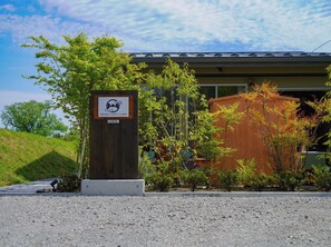 A modern building with a sign for Senko Tiny Camp, surrounded by trees and a gravel area. - LOVEL BuildingA plan to rent an entire cottage e / Ueda City Nagano (Ueda City)