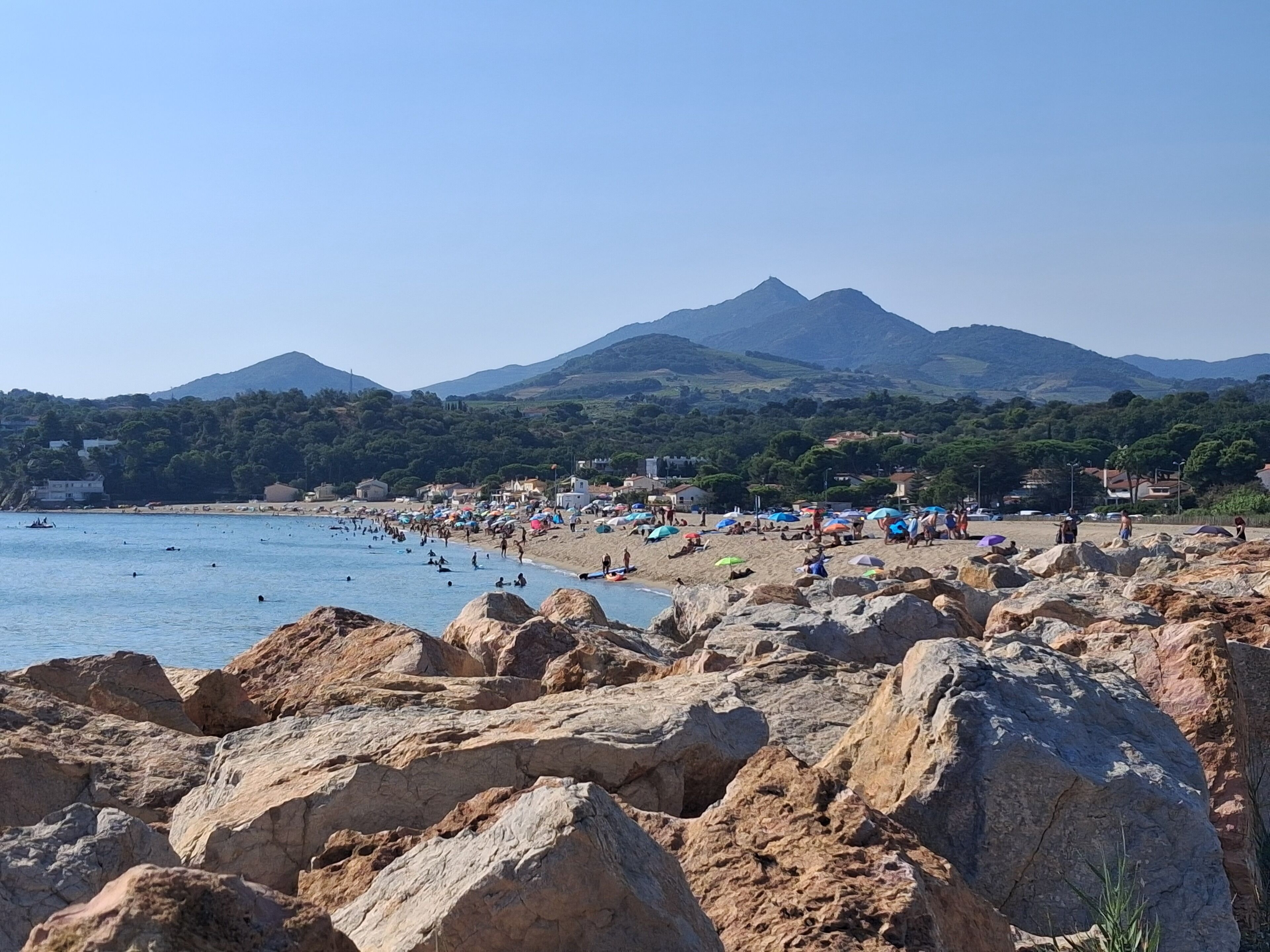 Una playa rocosa con una montaña al fondo.