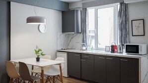 Eine moderne Küche mit Essbereich, einer Uhr und einem Fenster mit Vorhängen.