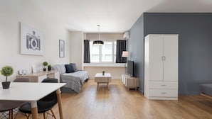 En modern lägenhet med ett matområde, en soffa, en TV och en garderob.