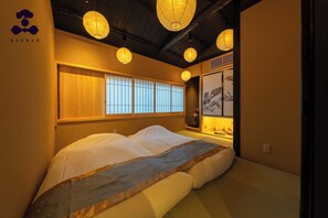 A traditional Japanese-style room with tatami flooring, a low bed, shoji screens, and hanging paper lanterns. - Hanaikada House 8minute walk from Kyoto Station / Kyoto City Kyōto (Kyoto City)