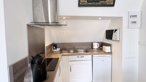 Una kitchenette compacta equipada con microondas, tostadora, pileta y un refrigerador pequeño.