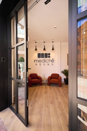 Et moderne interiør med en receptionsdisk, to sofaer og et skilt med teksten 'mediché rooms'.
