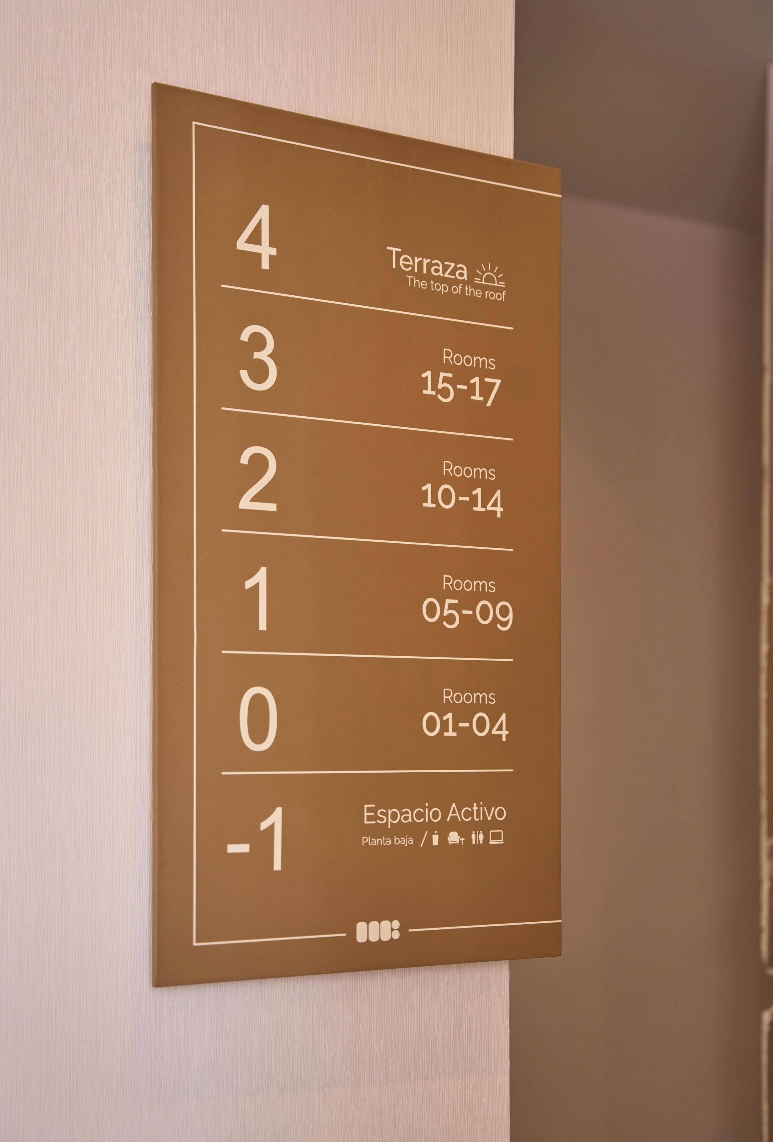 Un cartel de número de habitación de hotel con números de habitación y las habitaciones correspondientes.