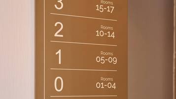 Un cartel de número de habitación de hotel con números de habitación y las habitaciones correspondientes.