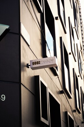 A building with a sign that reads 'mediché rooms' and a number '99' on the facade.