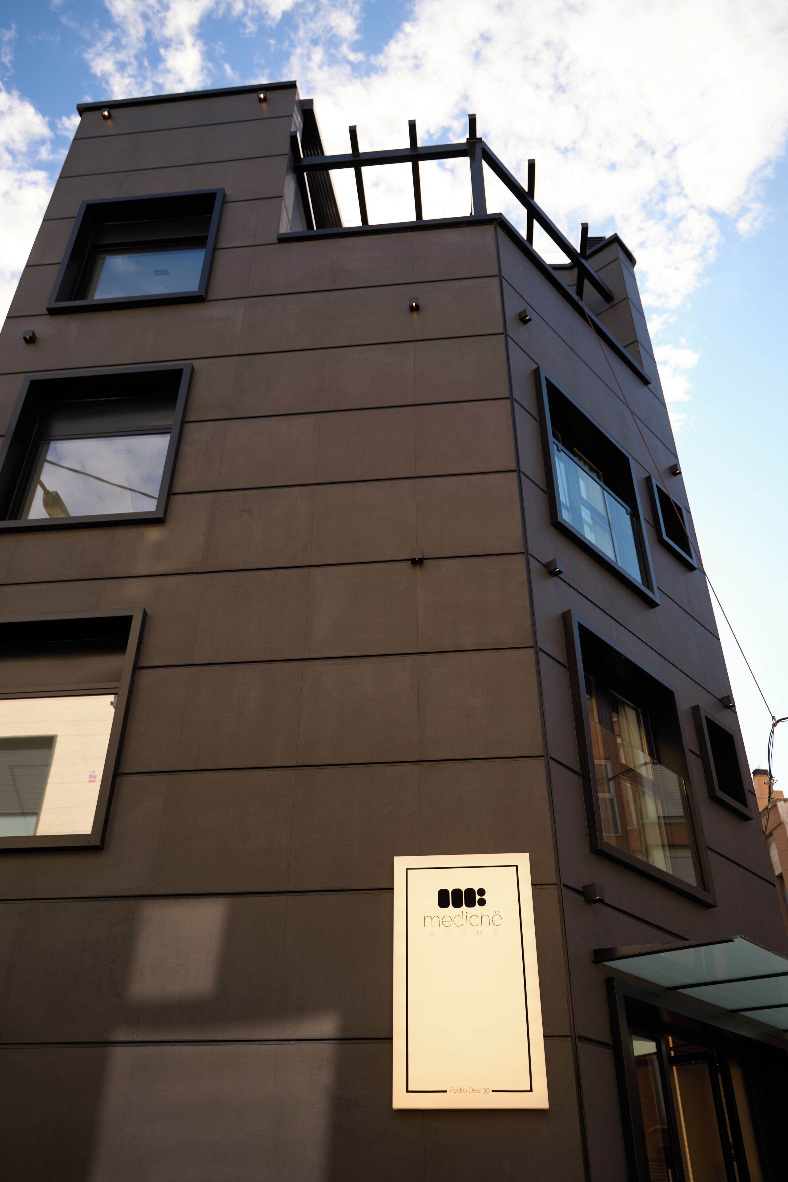 Un edificio moderno con múltiples ventanas y un letrero que dice 'mediché'.